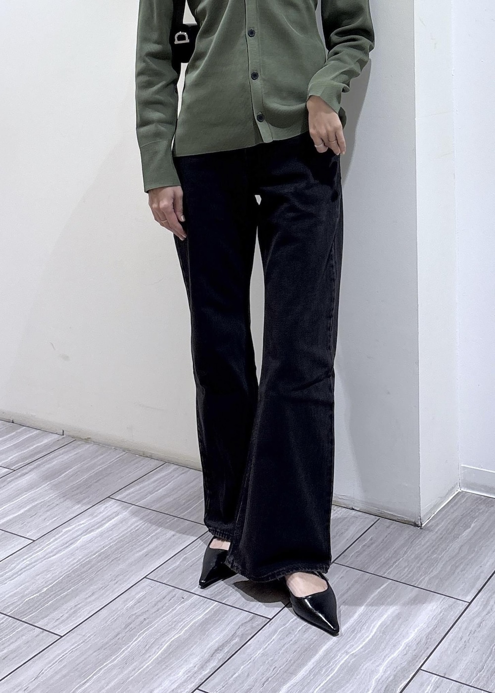 ブラック系のパンプス、ブラック系のショルダーバッグを着用したレディースの春コーディネートの5枚目の写真