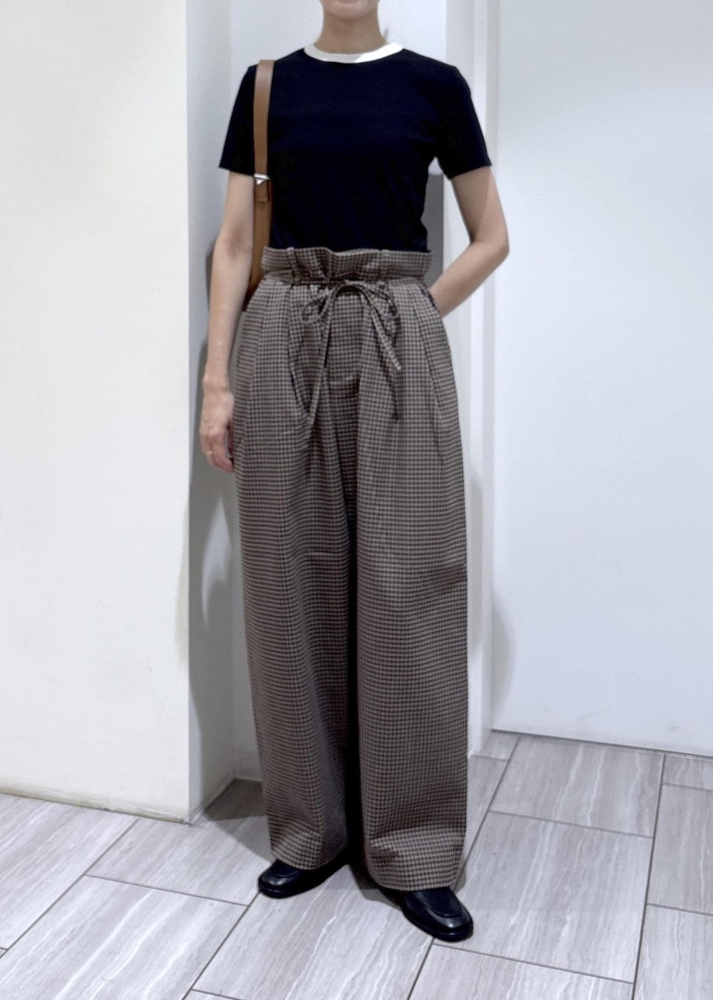 ブラック系のローファー、ブラウン系のスラックス、ブラック系のTシャツ/カットソーを着用したレディースの夏コーディネートの7枚目の写真