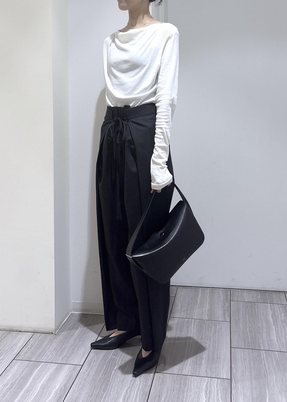 ブラック系のショルダーバッグ、ブラック系のパンプス、ホワイト系のTシャツ/カットソーを着用したレディースの夏コーディネートの3枚目の写真