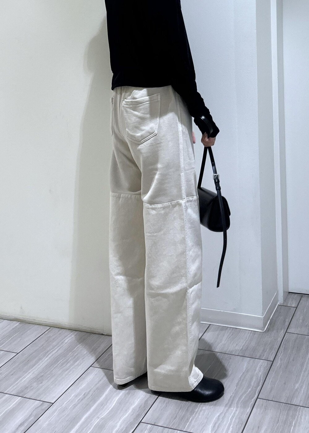 ブラック系のブーツ、ブラック系のカーディガン/ボレロ、ブラック系のショルダーバッグを着用したレディースの秋コーディネートの4枚目の写真