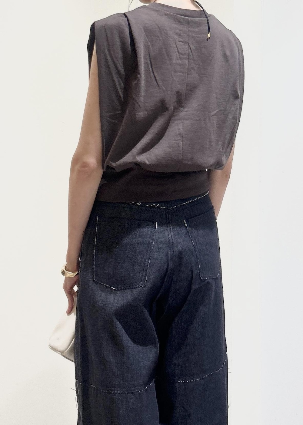 ブラック系のサンダル、ホワイト系のハンドバッグ、ブラウン系のTシャツ/カットソーを着用したレディースの春コーディネートの4枚目の写真