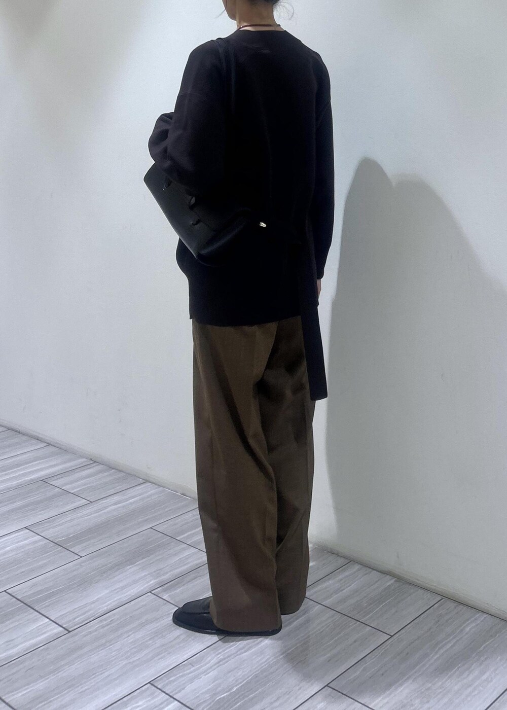 ブラック系のローファー、イエロー系のスラックス、ブラウン系のカーディガン/ボレロを着用したレディースの秋コーディネートの4枚目の写真