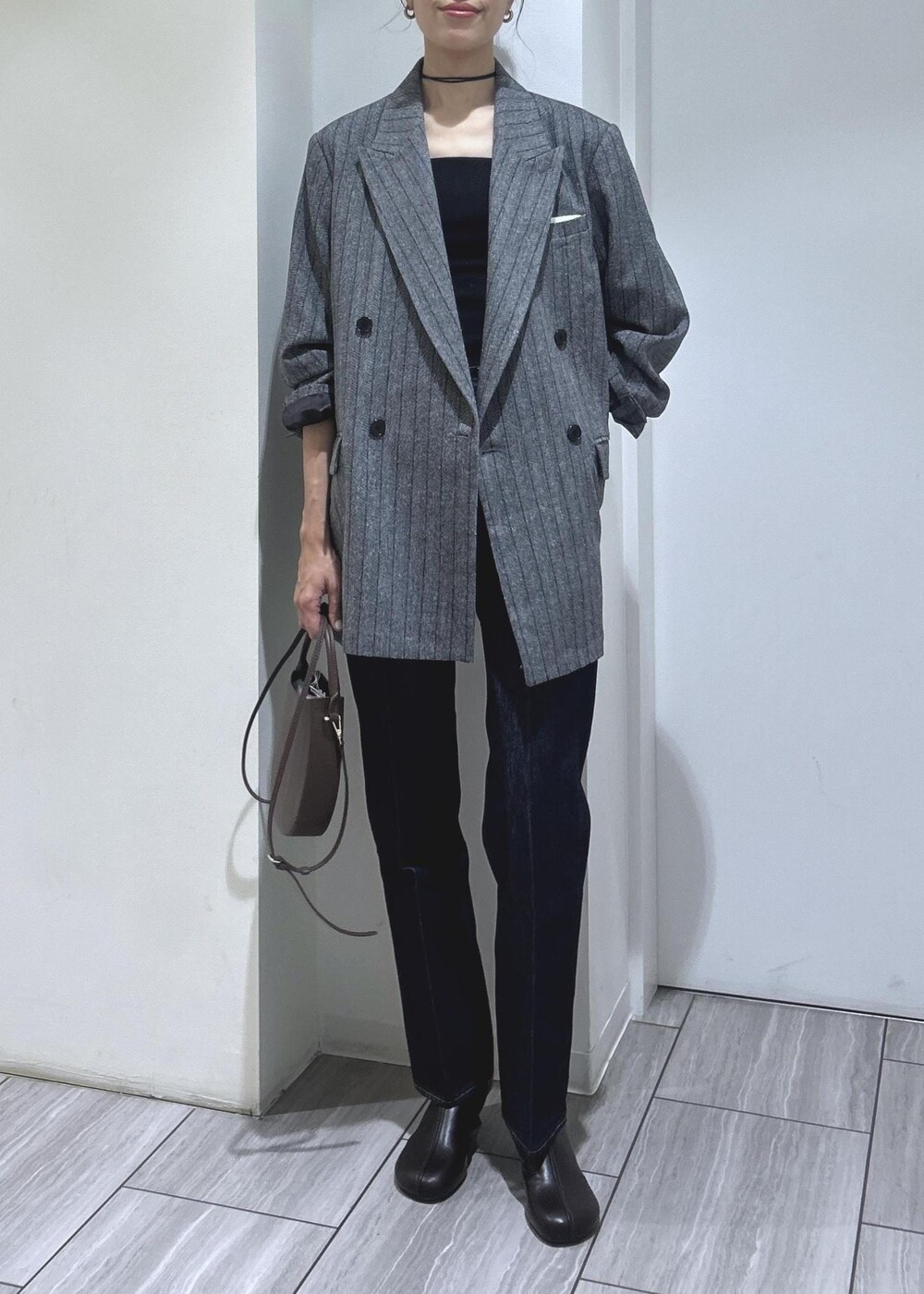 ブラック系のキャミソール、グレー系のテーラードジャケット、ブラウン系のブーツを着用したレディースの秋コーディネートの2枚目の写真