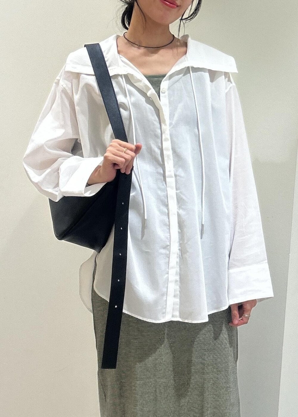 ホワイト系のシャツ/ブラウス、グリーン系のタンクトップ、グリーン系のスカートを着用したレディースの春コーディネートの3枚目の写真