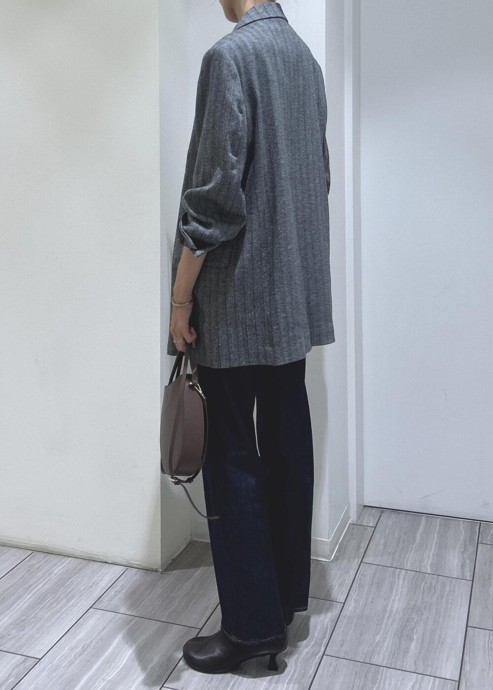 ブラック系のキャミソール、グレー系のテーラードジャケット、ブラウン系のブーツを着用したレディースの秋コーディネートの6枚目の写真