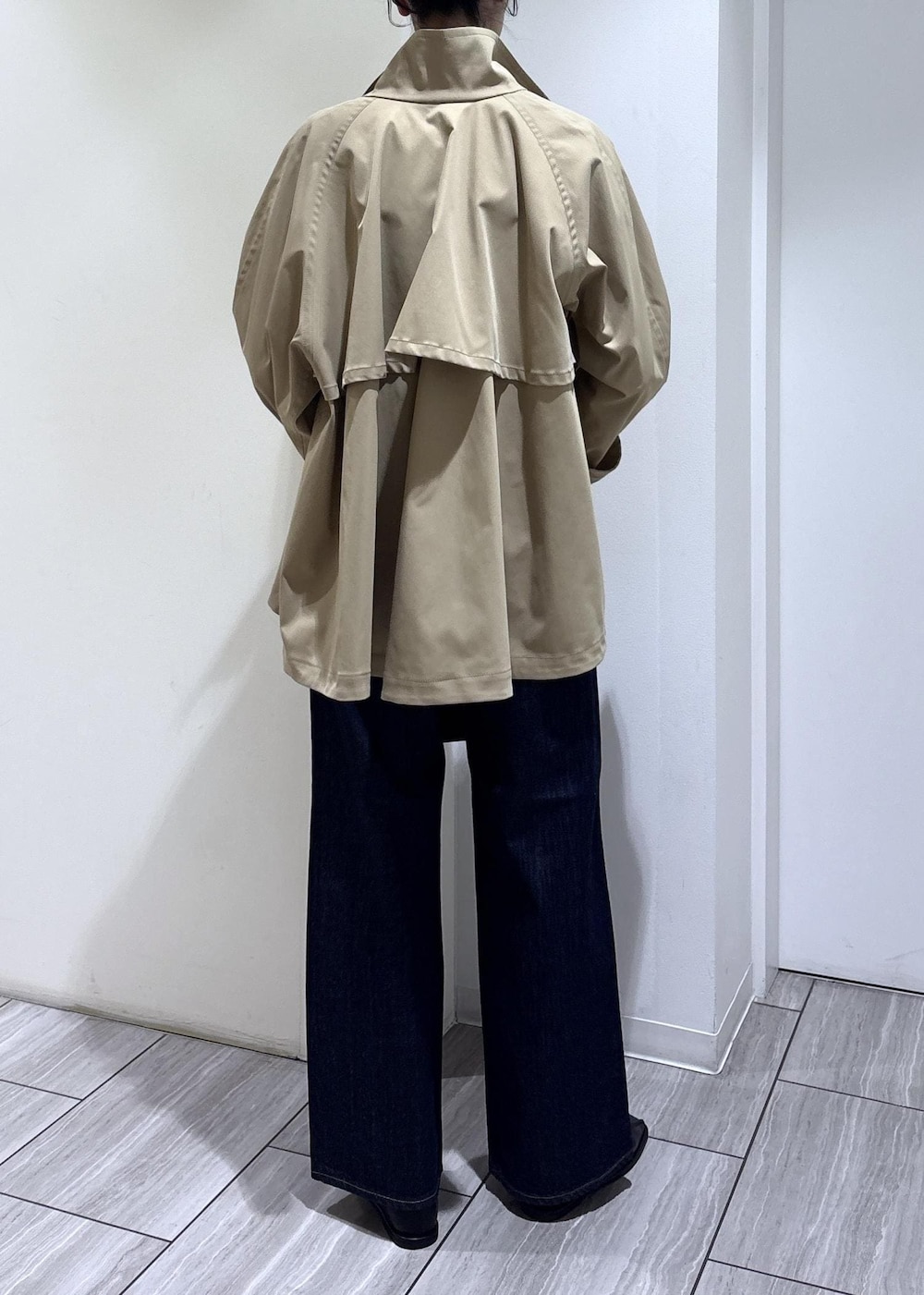 ブラック系のバレエシューズ、ブラック系のボストンバッグ、ベージュ系のトレンチコートを着用したレディースの春コーディネートの5枚目の写真