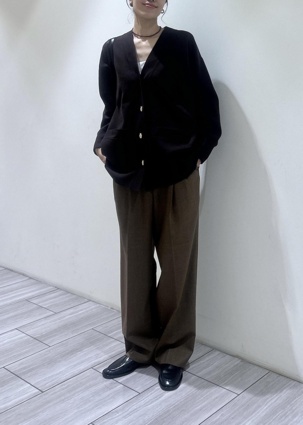 ブラック系のローファー、イエロー系のスラックス、ブラウン系のカーディガン/ボレロを着用したレディースの秋コーディネートの2枚目の写真