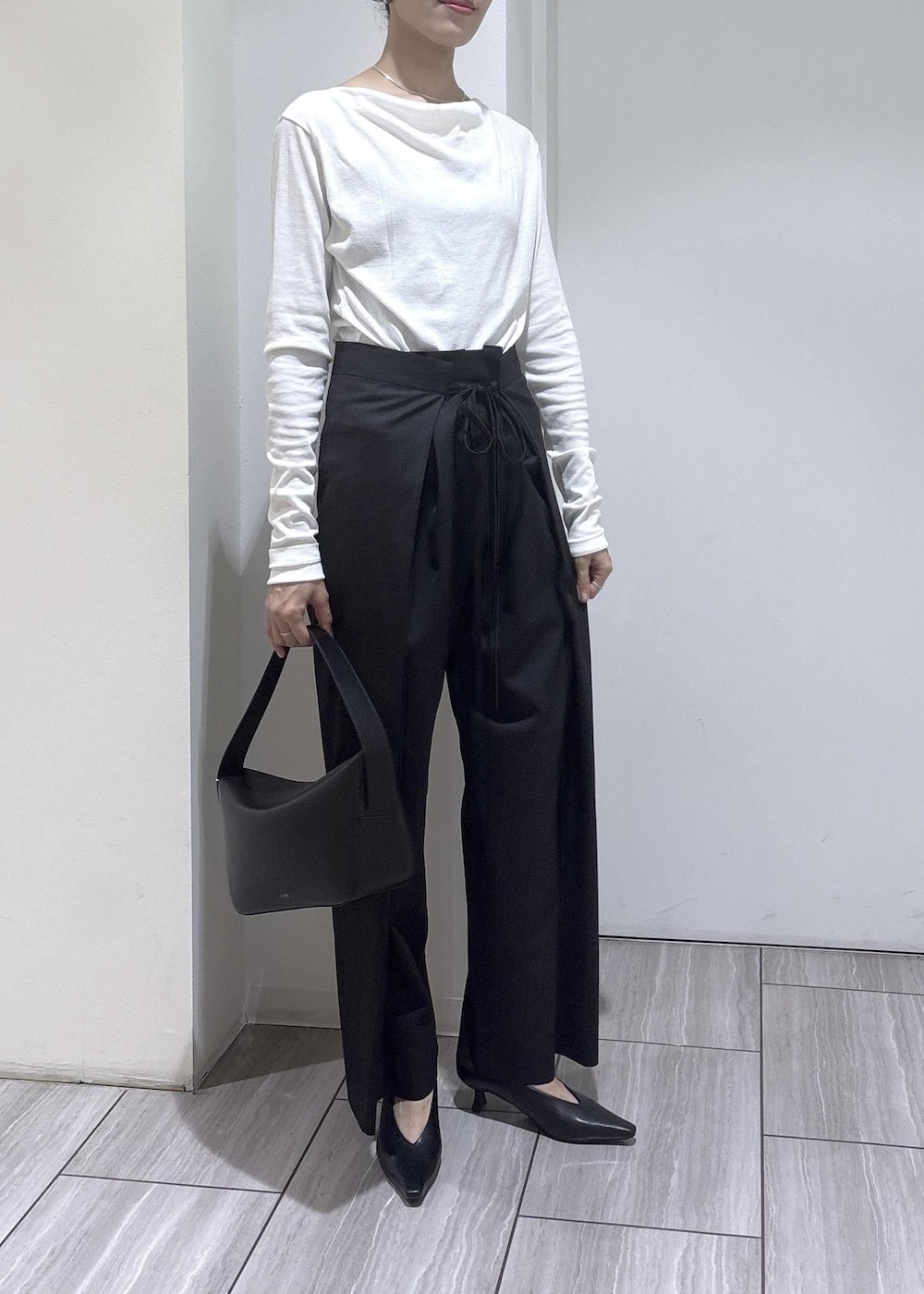 ブラック系のショルダーバッグ、ブラック系のパンプス、ホワイト系のTシャツ/カットソーを着用したレディースの夏コーディネートの6枚目の写真