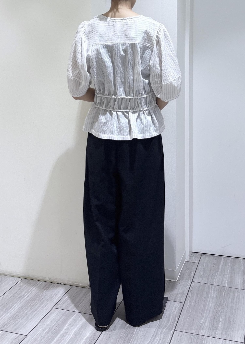 ブラック系のパンプス、ブラック系のショルダーバッグ、ホワイト系のシャツ/ブラウスを着用したレディースの春コーディネートの5枚目の写真
