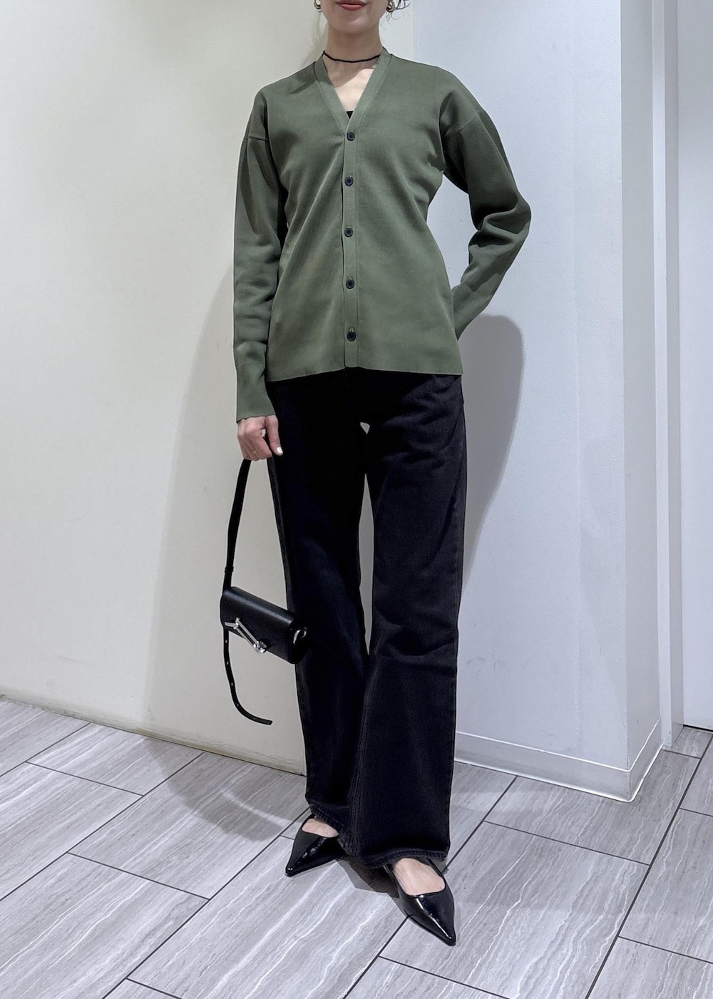 ブラック系のパンプス、ブラック系のショルダーバッグを着用したレディースの春コーディネートの2枚目の写真