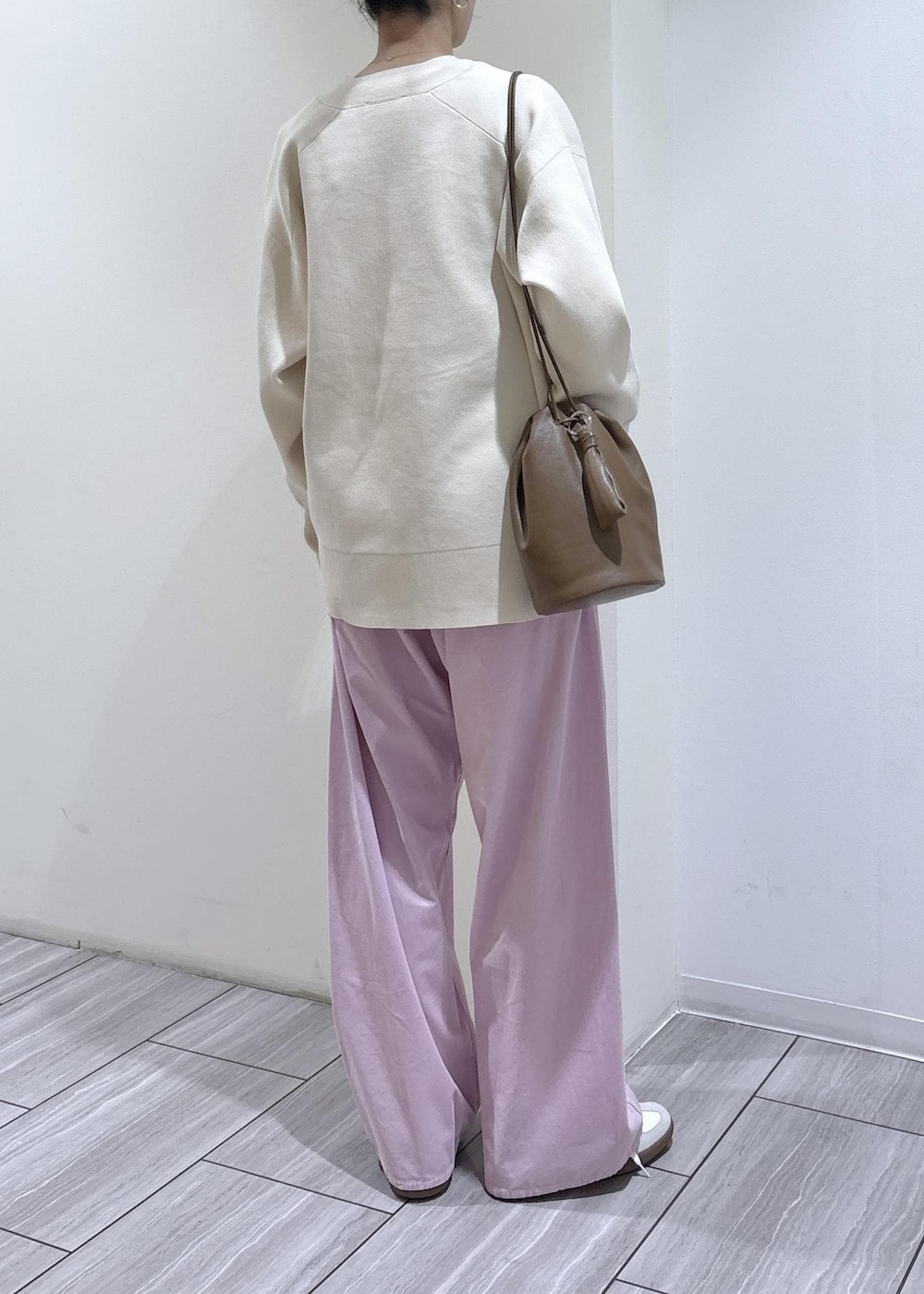 ホワイト系のスニーカー、ホワイト系のカーディガン/ボレロ、ブラウン系のショルダーバッグを着用したレディースの冬コーディネートの4枚目の写真