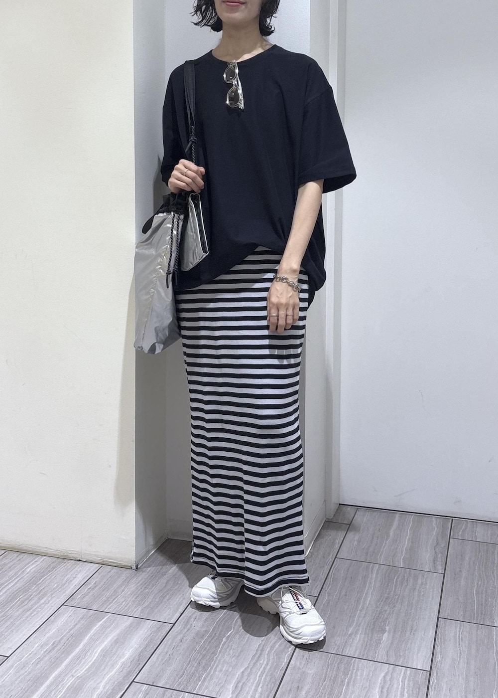 ブルー系のスカート、シルバー系のトートバッグ、ブルー系のTシャツ/カットソーを着用したレディースの夏コーディネートの7枚目の写真