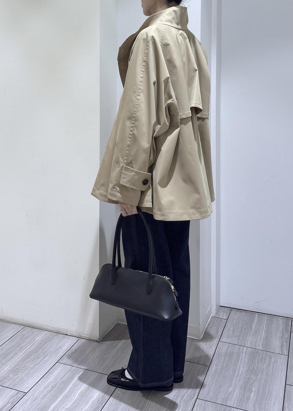 ブラック系のバレエシューズ、ブラック系のボストンバッグ、ベージュ系のトレンチコートを着用したレディースの春コーディネートの4枚目の写真