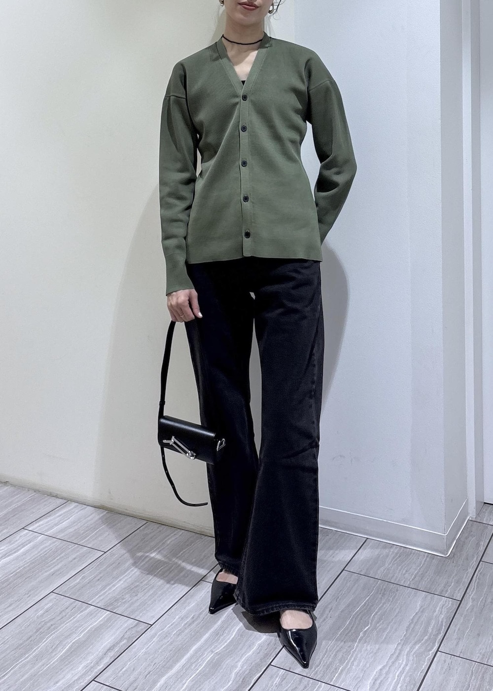 ブラック系のパンプス、ブラック系のショルダーバッグを着用したレディースの春コーディネートの7枚目の写真