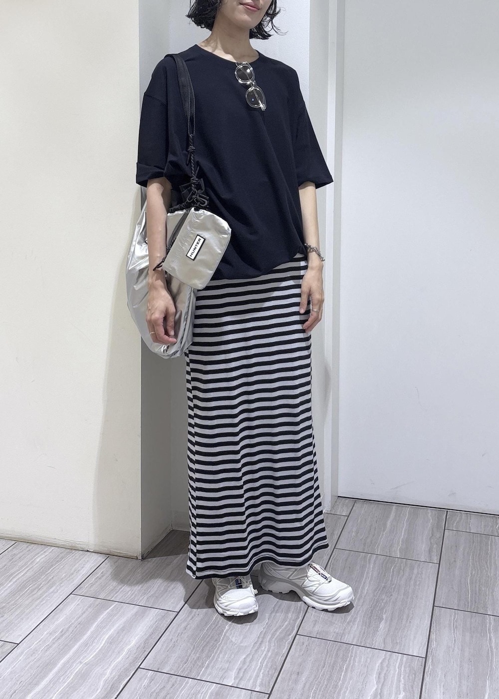 ブルー系のスカート、シルバー系のトートバッグ、ブルー系のTシャツ/カットソーを着用したレディースの夏コーディネートの6枚目の写真