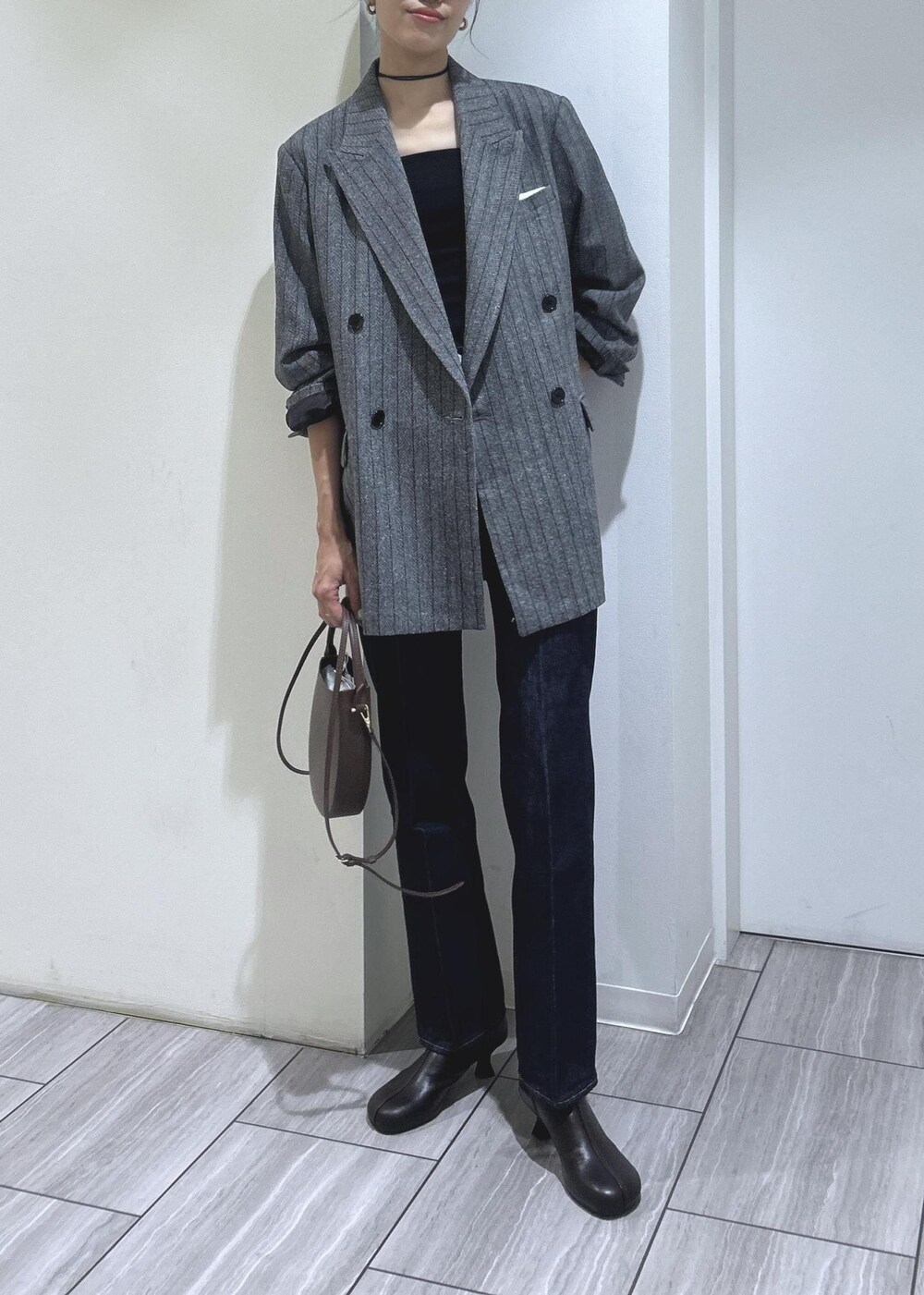 ブラック系のキャミソール、グレー系のテーラードジャケット、ブラウン系のブーツを着用したレディースの秋コーディネートの8枚目の写真