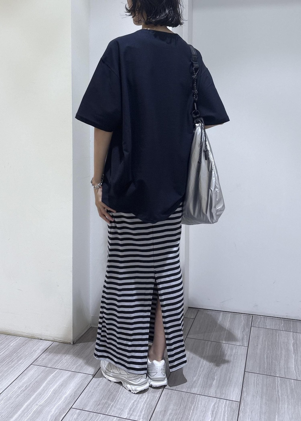 ブルー系のスカート、シルバー系のトートバッグ、ブルー系のTシャツ/カットソーを着用したレディースの夏コーディネートの4枚目の写真