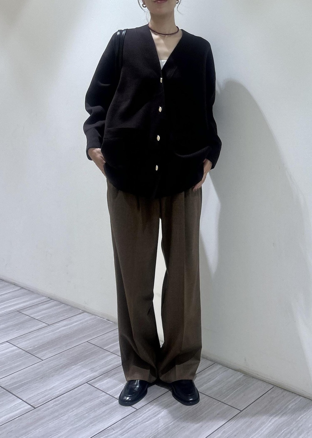 ブラック系のローファー、イエロー系のスラックス、ブラウン系のカーディガン/ボレロを着用したレディースの秋コーディネートの7枚目の写真