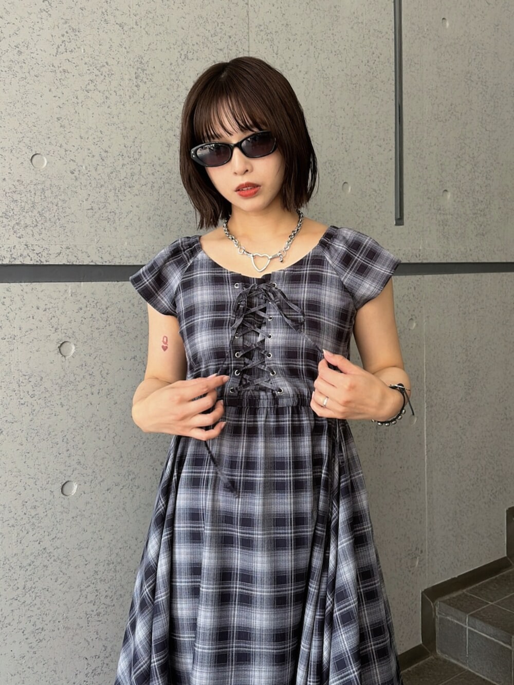 ブルー系のワンピース、ブラック系のブーツ、ブラック系のサングラスを着用したレディースの夏コーディネートの4枚目の写真