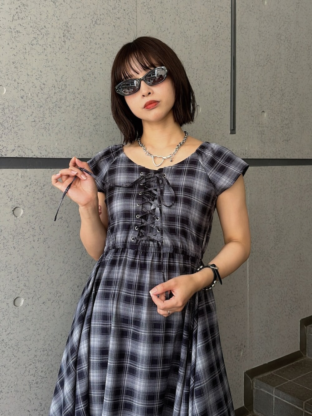ブルー系のワンピース、ブラック系のブーツ、ブラック系のサングラスを着用したレディースの夏コーディネートの5枚目の写真
