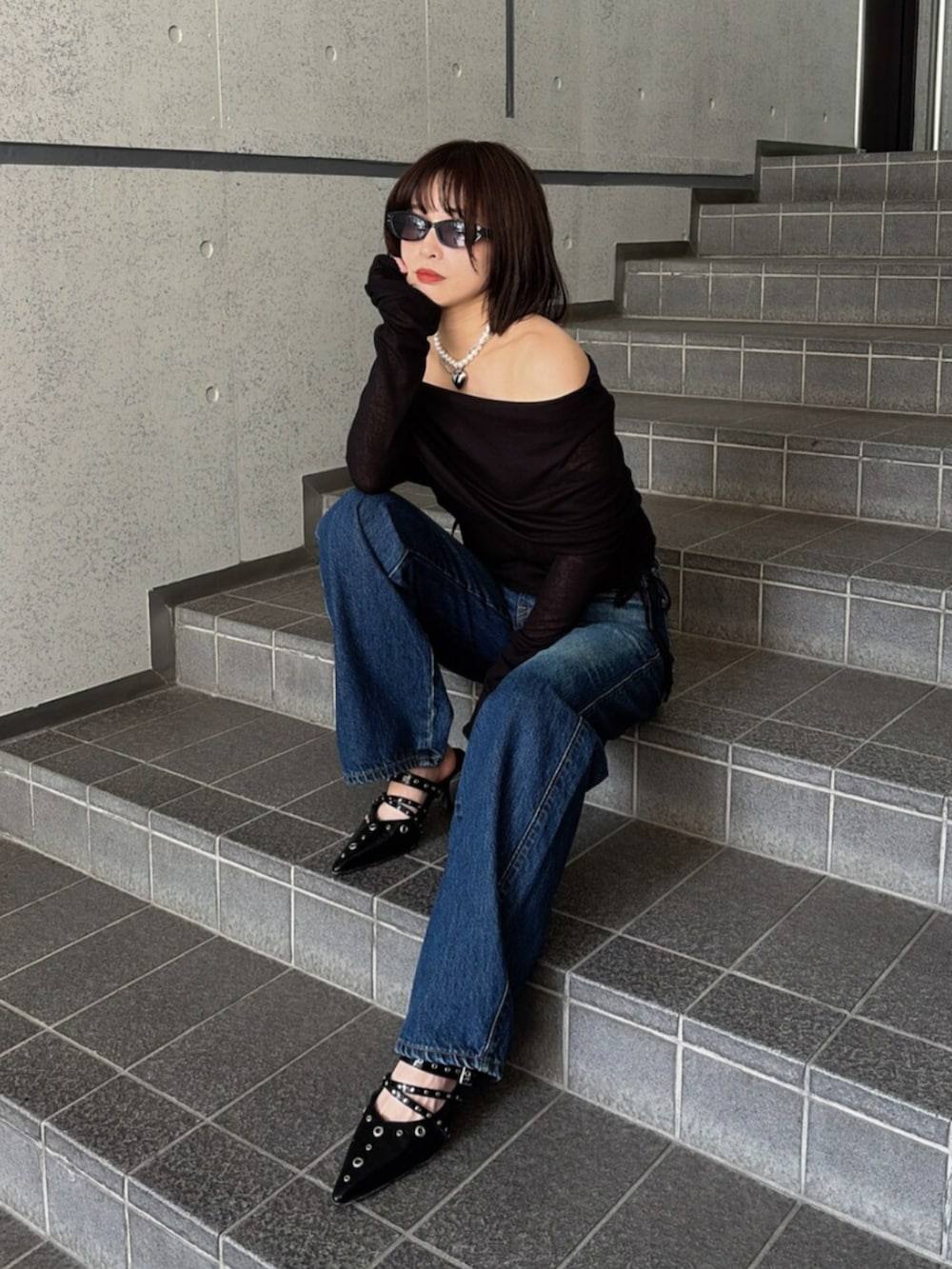 ブルー系のデニムパンツ、ブラック系のTシャツ/カットソー、ブラック系のパンプスを着用したレディースの夏コーディネートの8枚目の写真