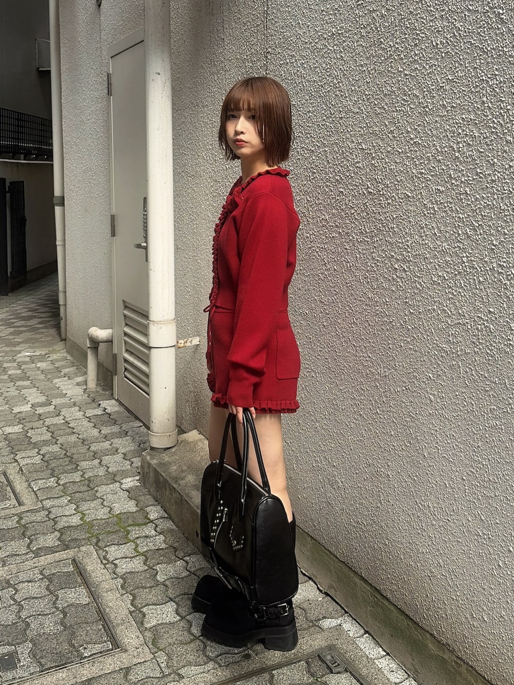 レッド系のカーディガン/ボレロ、レッド系のその他パンツ、ブラック系のハンドバッグを着用したレディースの秋コーディネートの2枚目の写真
