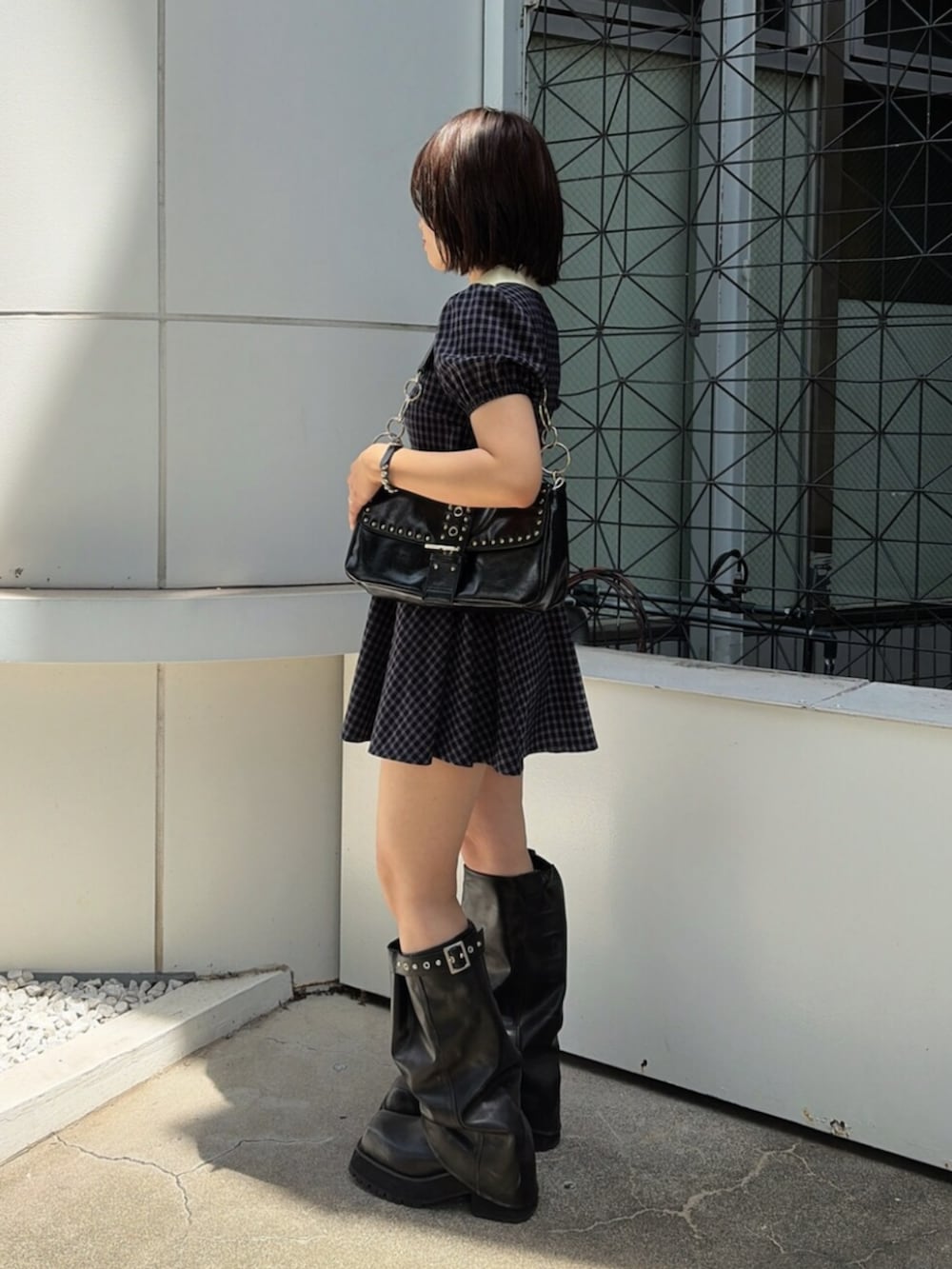 ブルー系のワンピース、ブラック系のハンドバッグ、ブラック系のブーツを着用したレディースの夏コーディネートの2枚目の写真