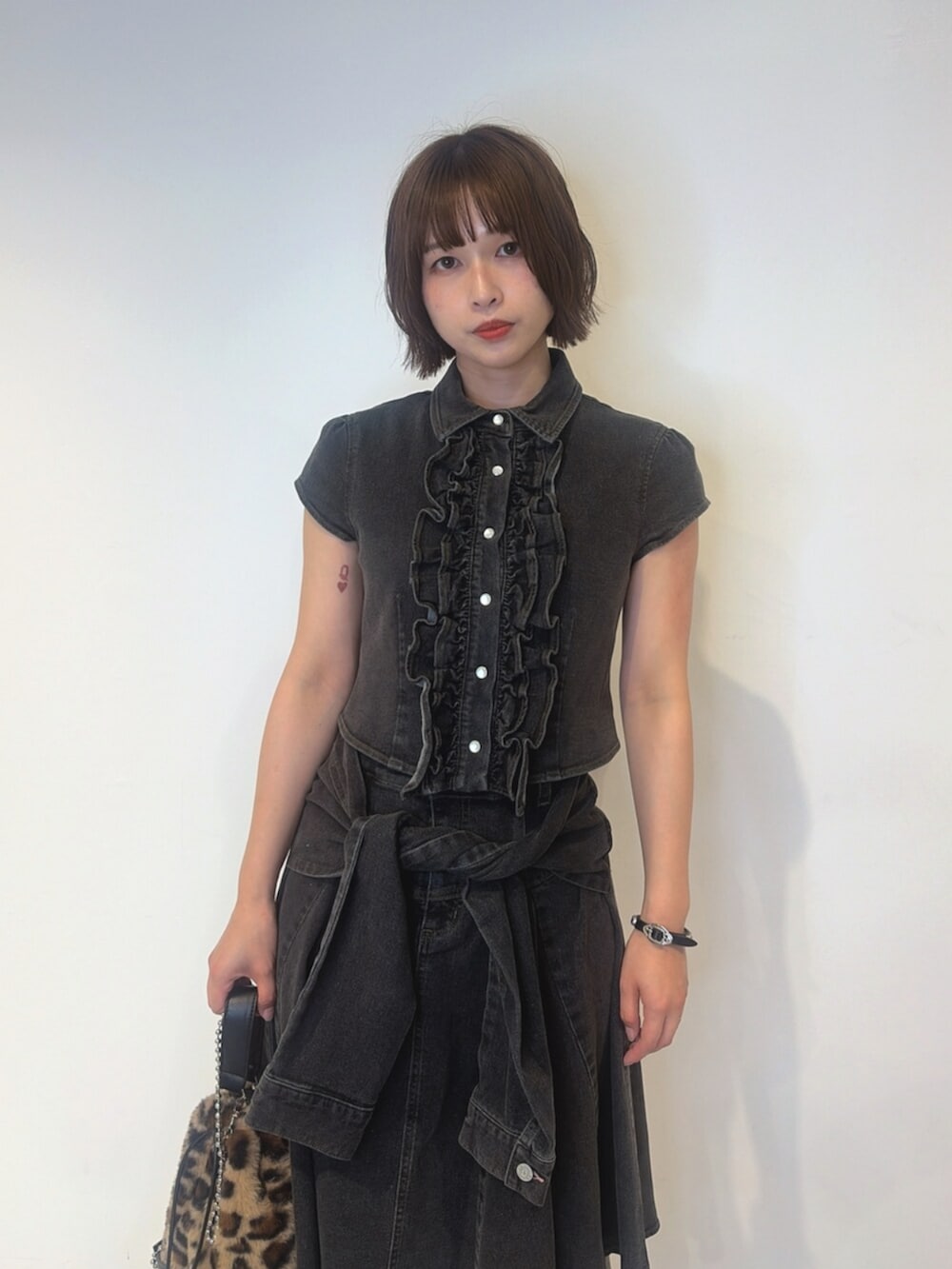 ブラック系のシャツ/ブラウス、ブラック系のスカート、ブラウン系のハンドバッグを着用したレディースの夏コーディネートの4枚目の写真