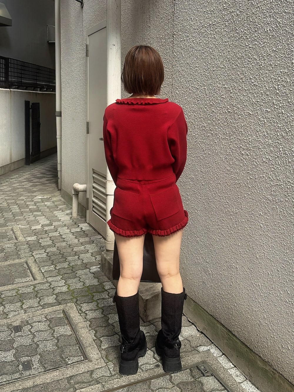 レッド系のカーディガン/ボレロ、レッド系のその他パンツ、ブラック系のハンドバッグを着用したレディースの秋コーディネートの3枚目の写真
