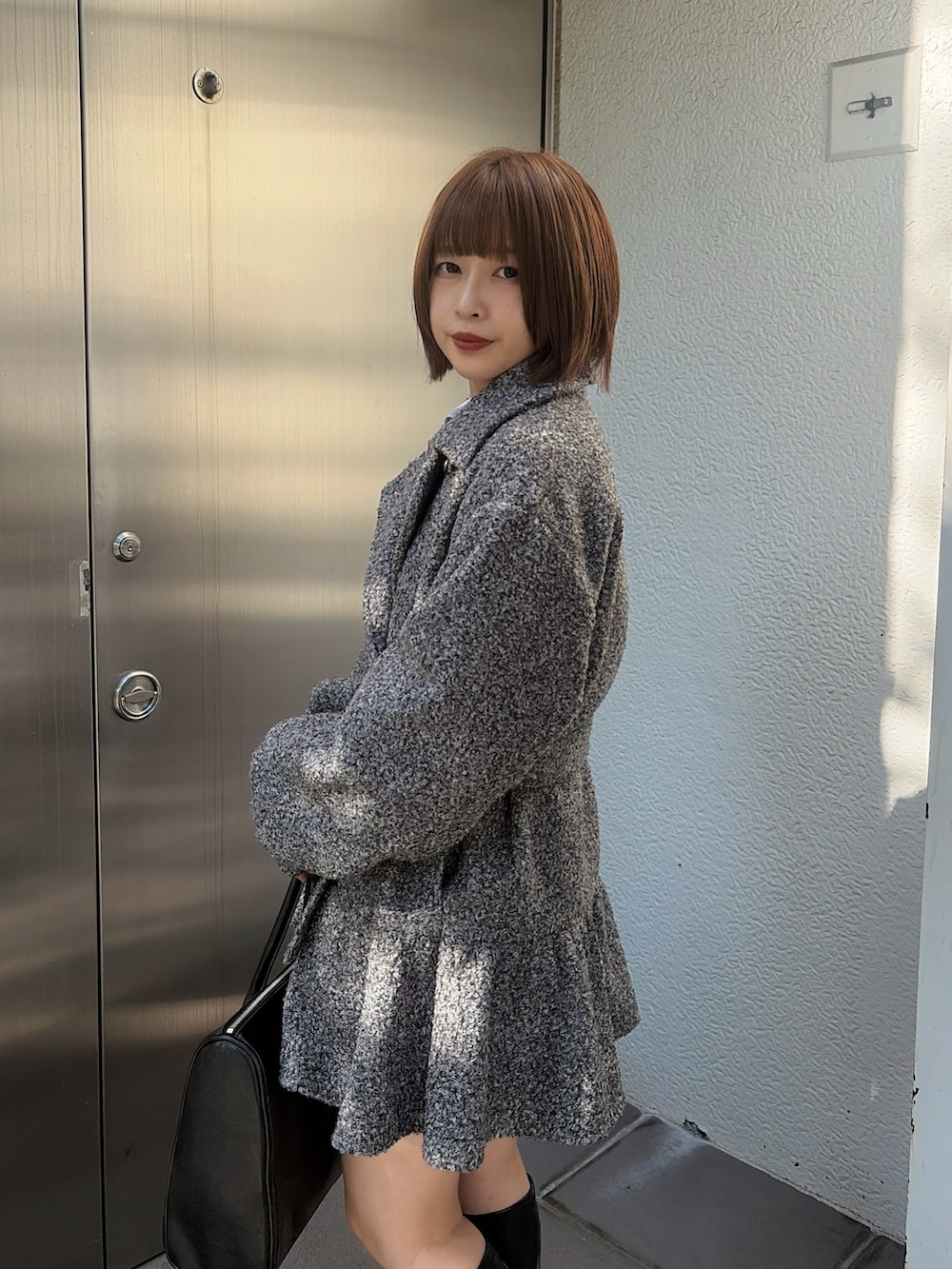 ブルー系のシャツ/ブラウス、グレー系のトレンチコート、ブラック系のハンドバッグを着用したレディースの秋コーディネートの4枚目の写真