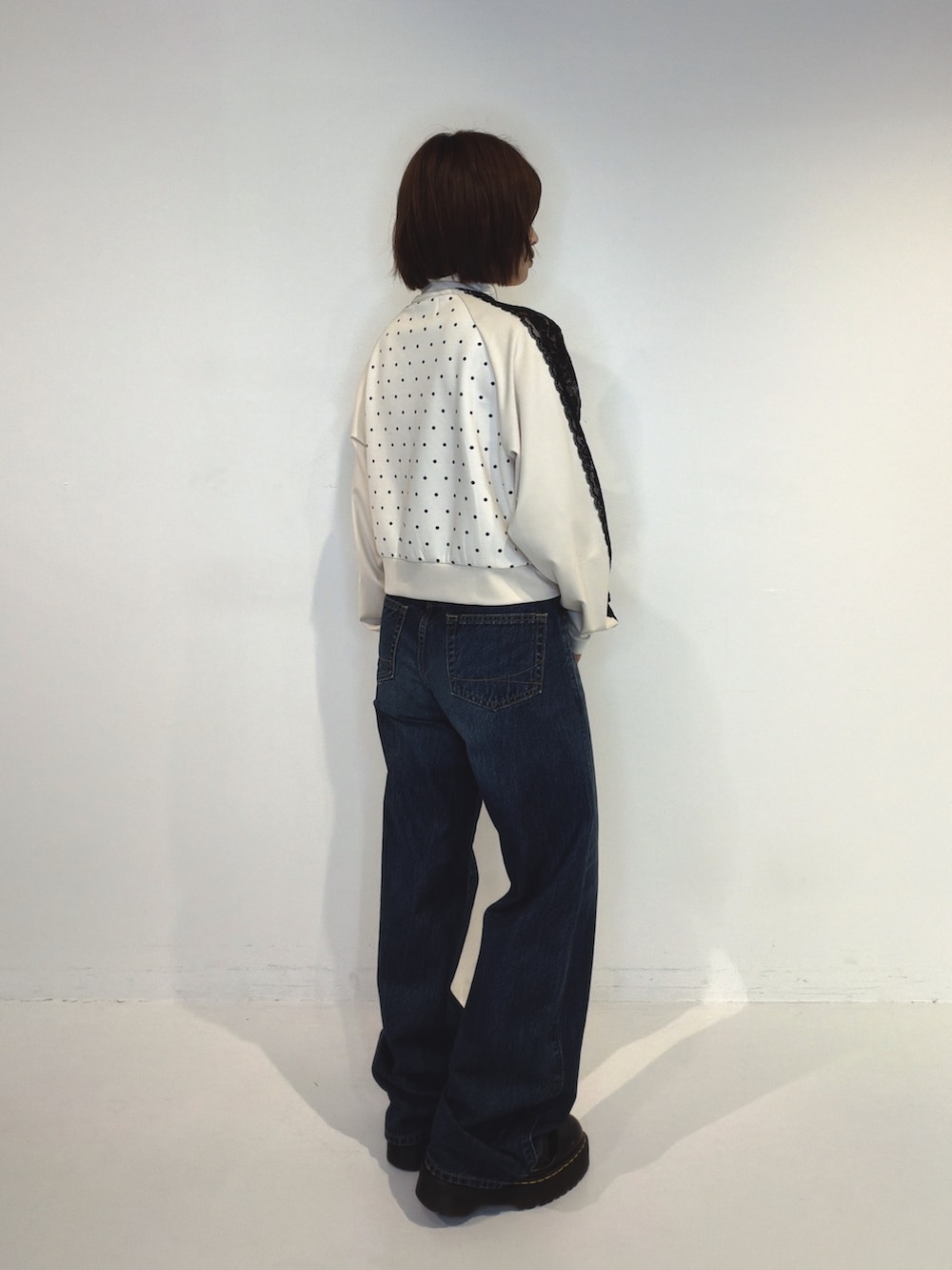ブルー系のデニムパンツ、ホワイト系のTシャツ/カットソーを着用したレディースの秋コーディネートの3枚目の写真