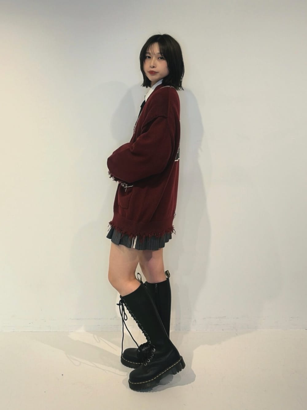 レッド系のカーディガン/ボレロ、ホワイト系のシャツ/ブラウス、グレー系のスカートを着用したレディースの夏コーディネートの2枚目の写真