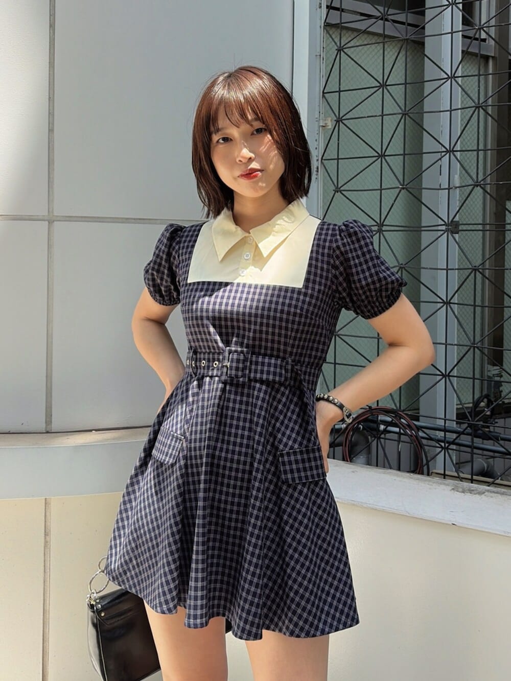 ブルー系のワンピース、ブラック系のハンドバッグ、ブラック系のブーツを着用したレディースの夏コーディネートの5枚目の写真