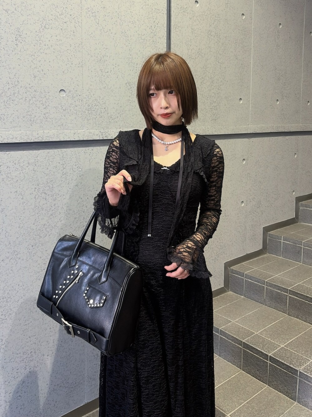ブラック系のブーツ、ブラック系のハンドバッグ、ブラック系のワンピースを着用したレディースの秋コーディネートの6枚目の写真