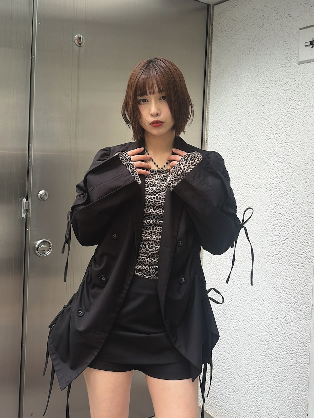 ブラウン系のTシャツ/カットソー、ブラック系のスカート、レッド系のブーツを着用したレディースの秋コーディネートの5枚目の写真