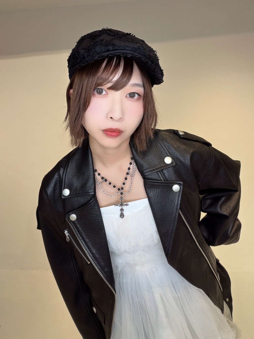 ブルー系のデニムパンツ、ホワイト系のワンピース、ブラック系のライダースジャケットを着用したレディースの秋コーディネートの7枚目の写真