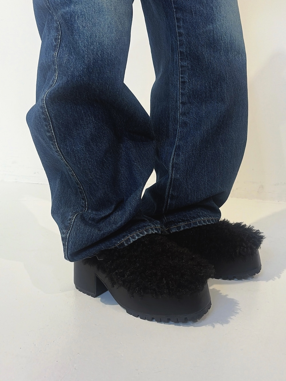 ブルー系のデニムパンツ、ブラック系のサンダル、グレー系のニット/セーターを着用したレディースの秋コーディネートの7枚目の写真