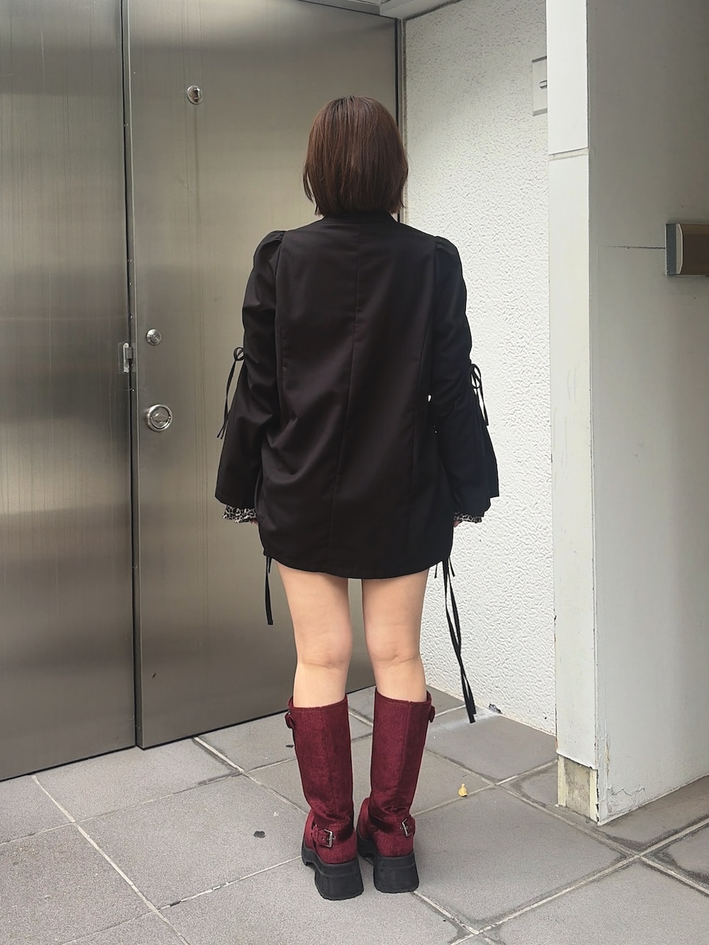 ブラウン系のTシャツ/カットソー、ブラック系のスカート、レッド系のブーツを着用したレディースの秋コーディネートの3枚目の写真