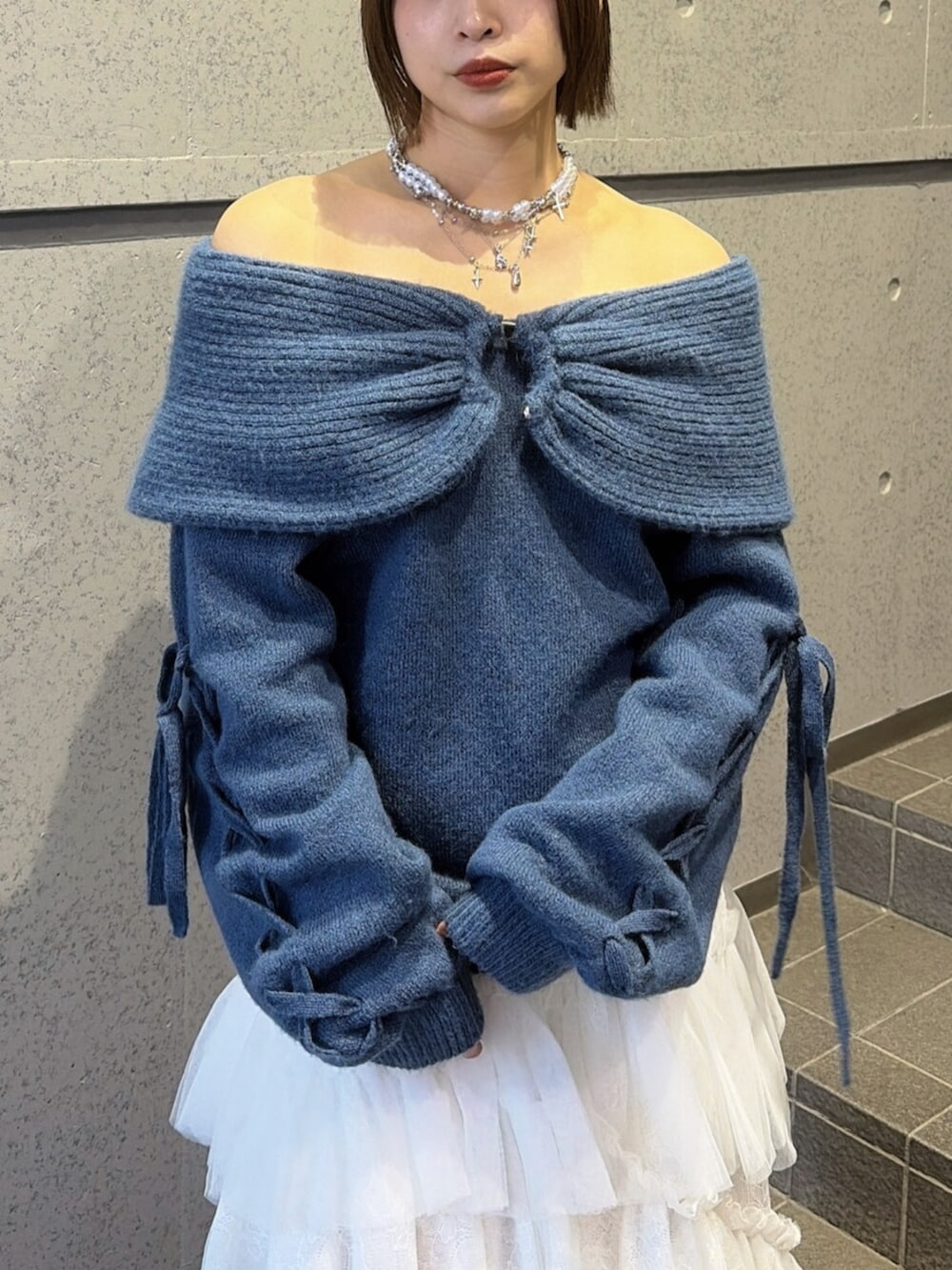 ホワイト系のスカート、ブラック系のブーツ、ブルー系のニット/セーターを着用したレディースの秋コーディネートの6枚目の写真