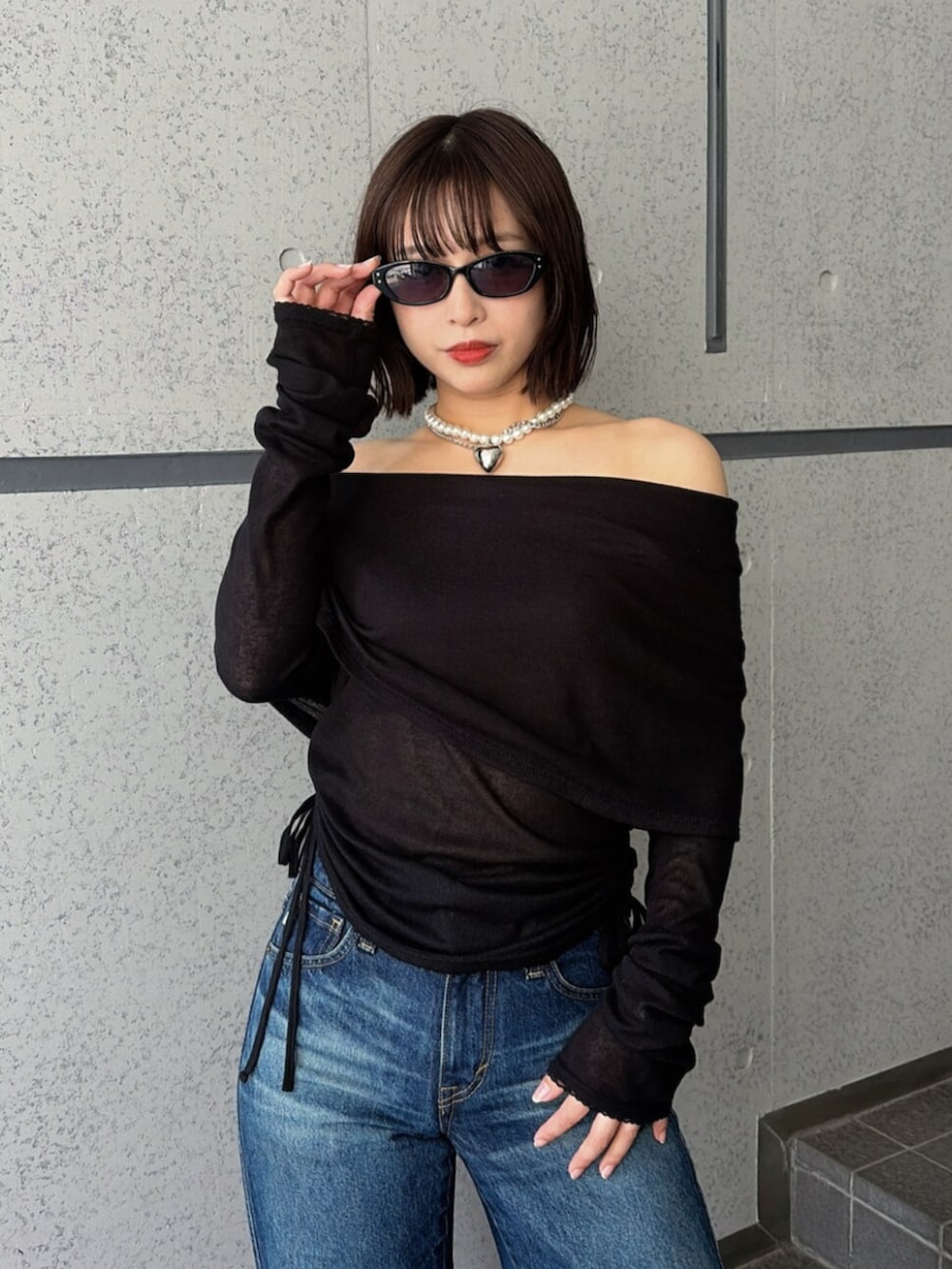 ブルー系のデニムパンツ、ブラック系のTシャツ/カットソー、ブラック系のパンプスを着用したレディースの夏コーディネートの6枚目の写真