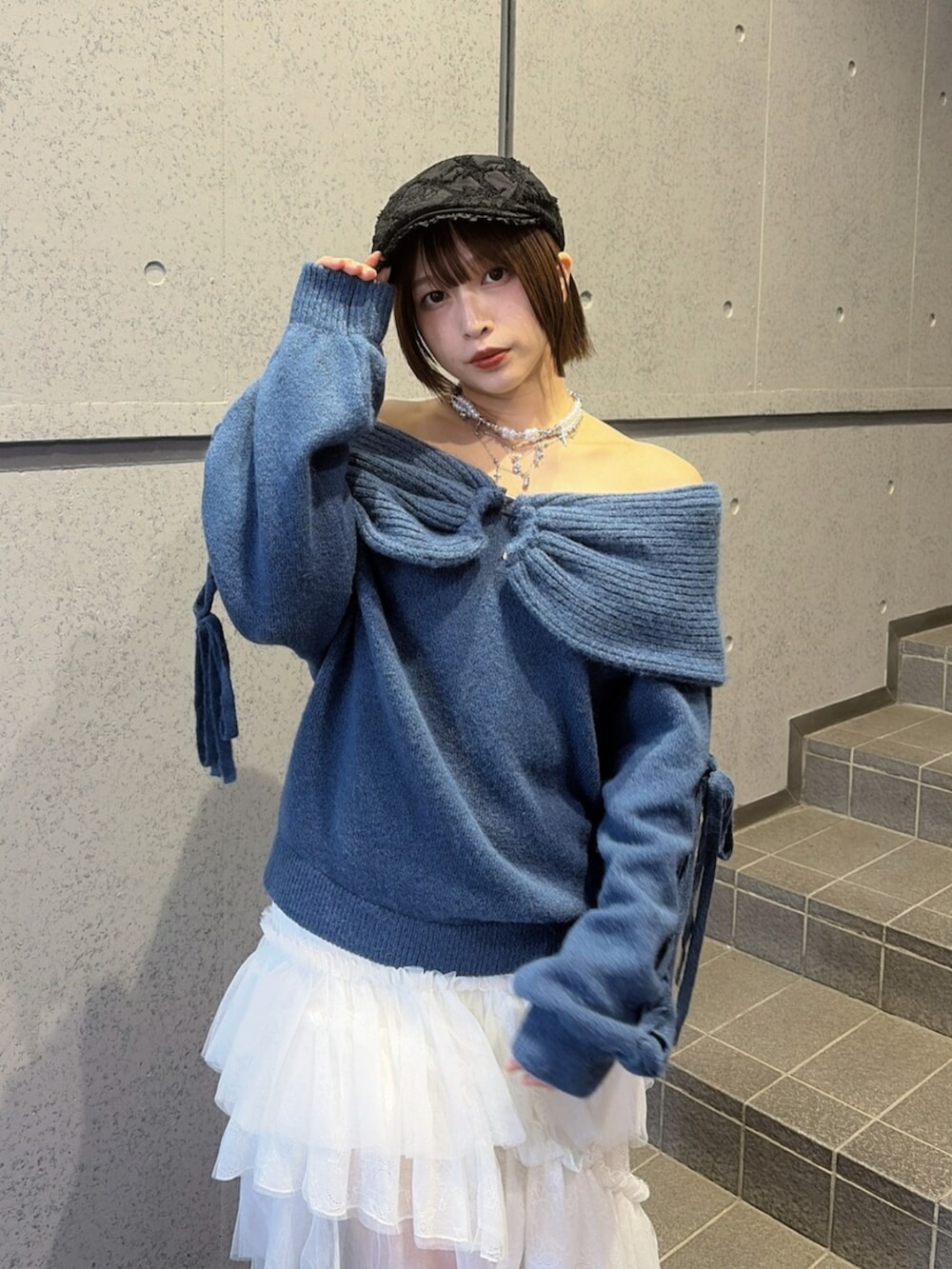 ホワイト系のスカート、ブラック系のブーツ、ブルー系のニット/セーターを着用したレディースの秋コーディネートの4枚目の写真