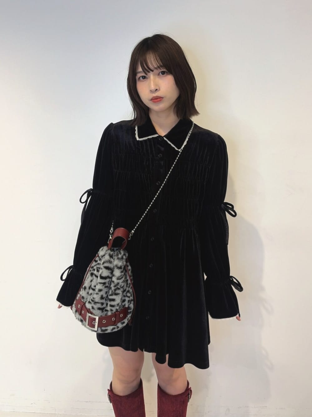 ブラック系のワンピース、グレー系のハンドバッグ、レッド系のブーツを着用したレディースの夏コーディネートの4枚目の写真