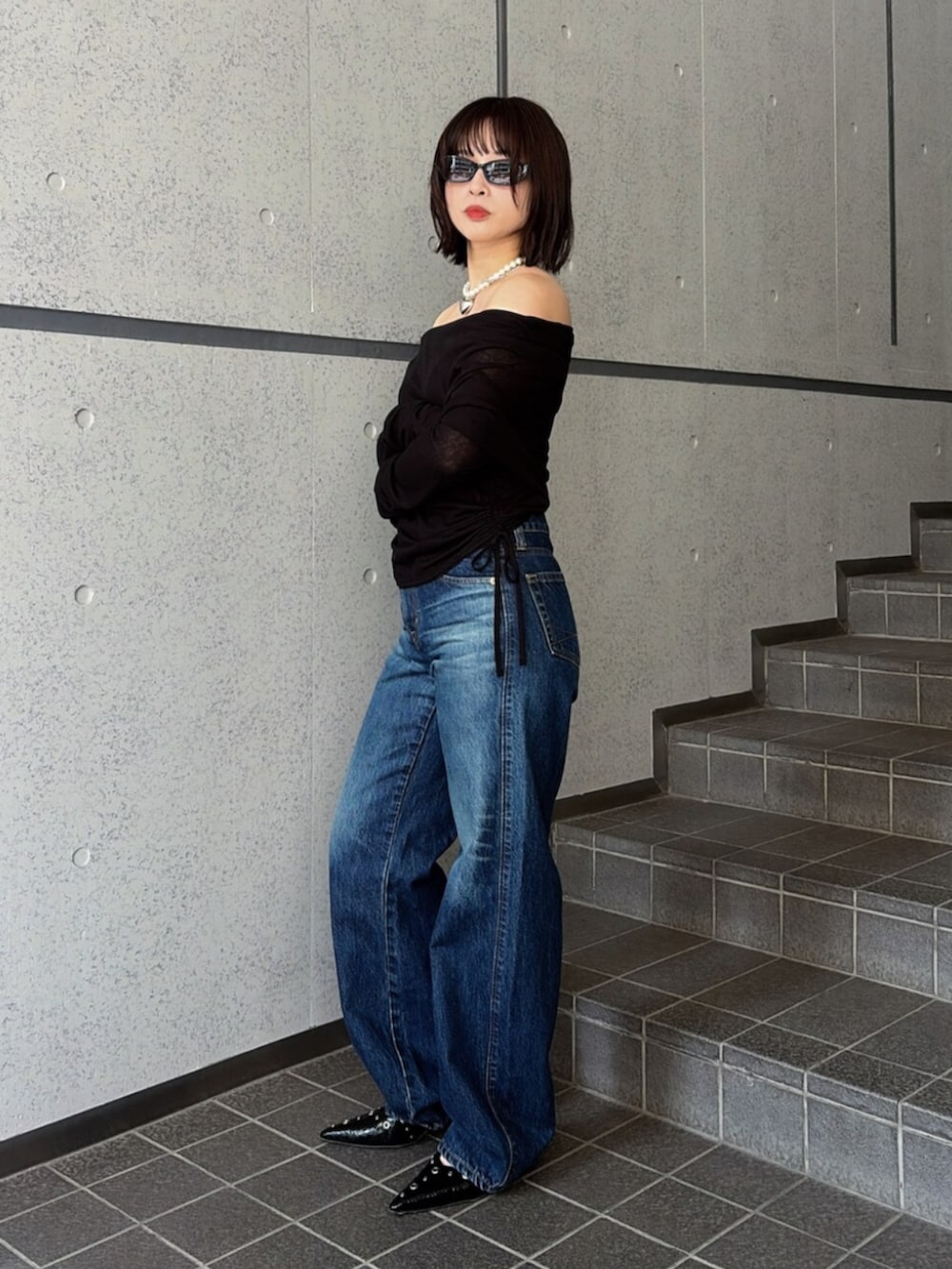 ブルー系のデニムパンツ、ブラック系のTシャツ/カットソー、ブラック系のパンプスを着用したレディースの夏コーディネートの2枚目の写真