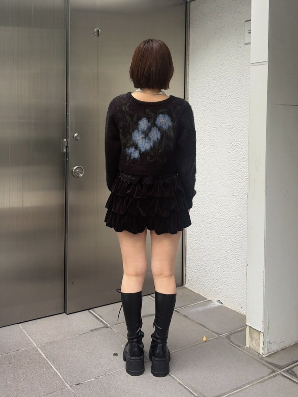 ブラック系のニット/セーター、ブラック系のスカート、ブラック系のブーツを着用したレディースの秋コーディネートの3枚目の写真