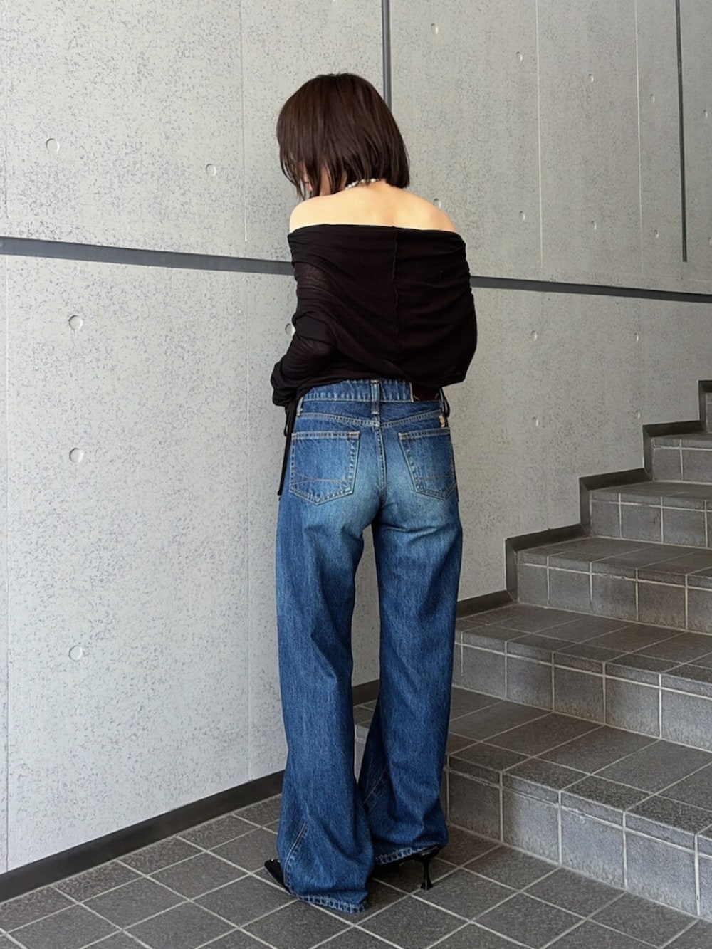ブルー系のデニムパンツ、ブラック系のTシャツ/カットソー、ブラック系のパンプスを着用したレディースの夏コーディネートの3枚目の写真