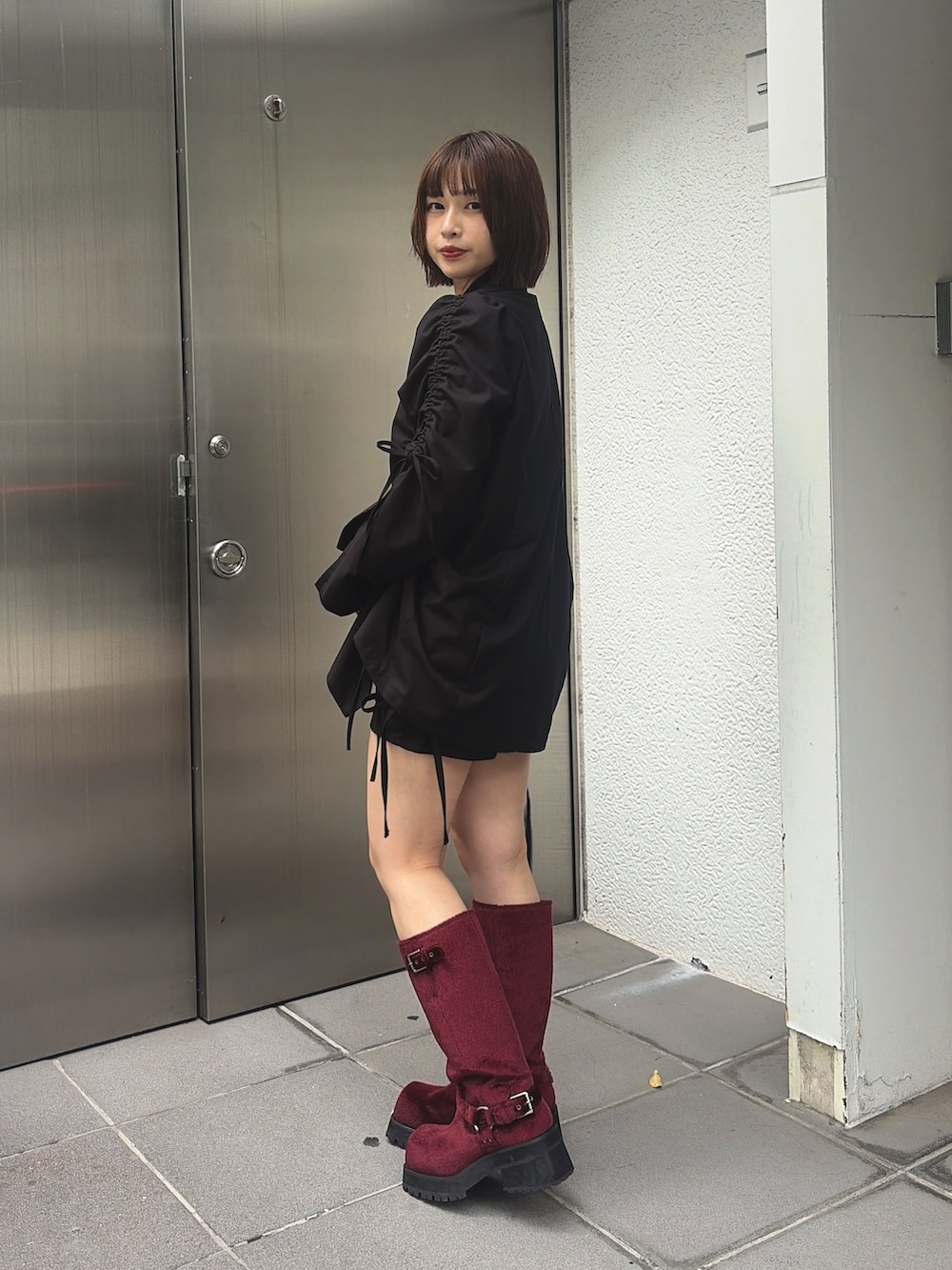 ブラウン系のTシャツ/カットソー、ブラック系のスカート、レッド系のブーツを着用したレディースの秋コーディネートの2枚目の写真