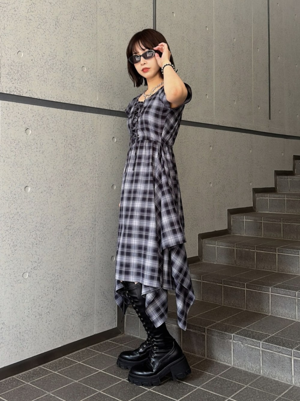 ブルー系のワンピース、ブラック系のブーツ、ブラック系のサングラスを着用したレディースの夏コーディネートの2枚目の写真