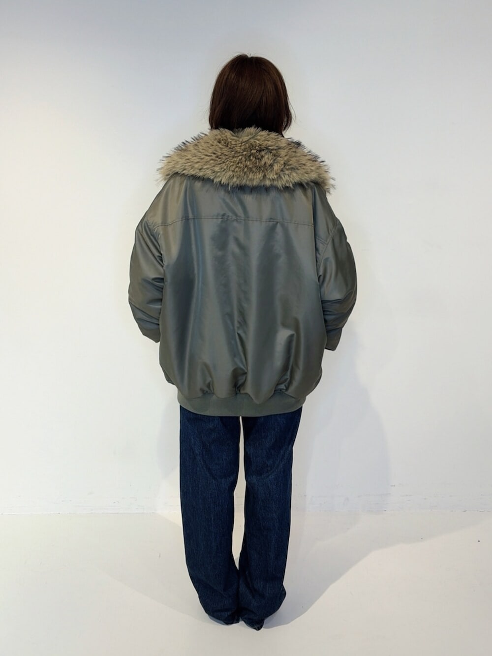 ブルー系のデニムパンツ、イエロー系のシャツ/ブラウス、グリーン系のMA-1を着用したレディースの秋コーディネートの3枚目の写真
