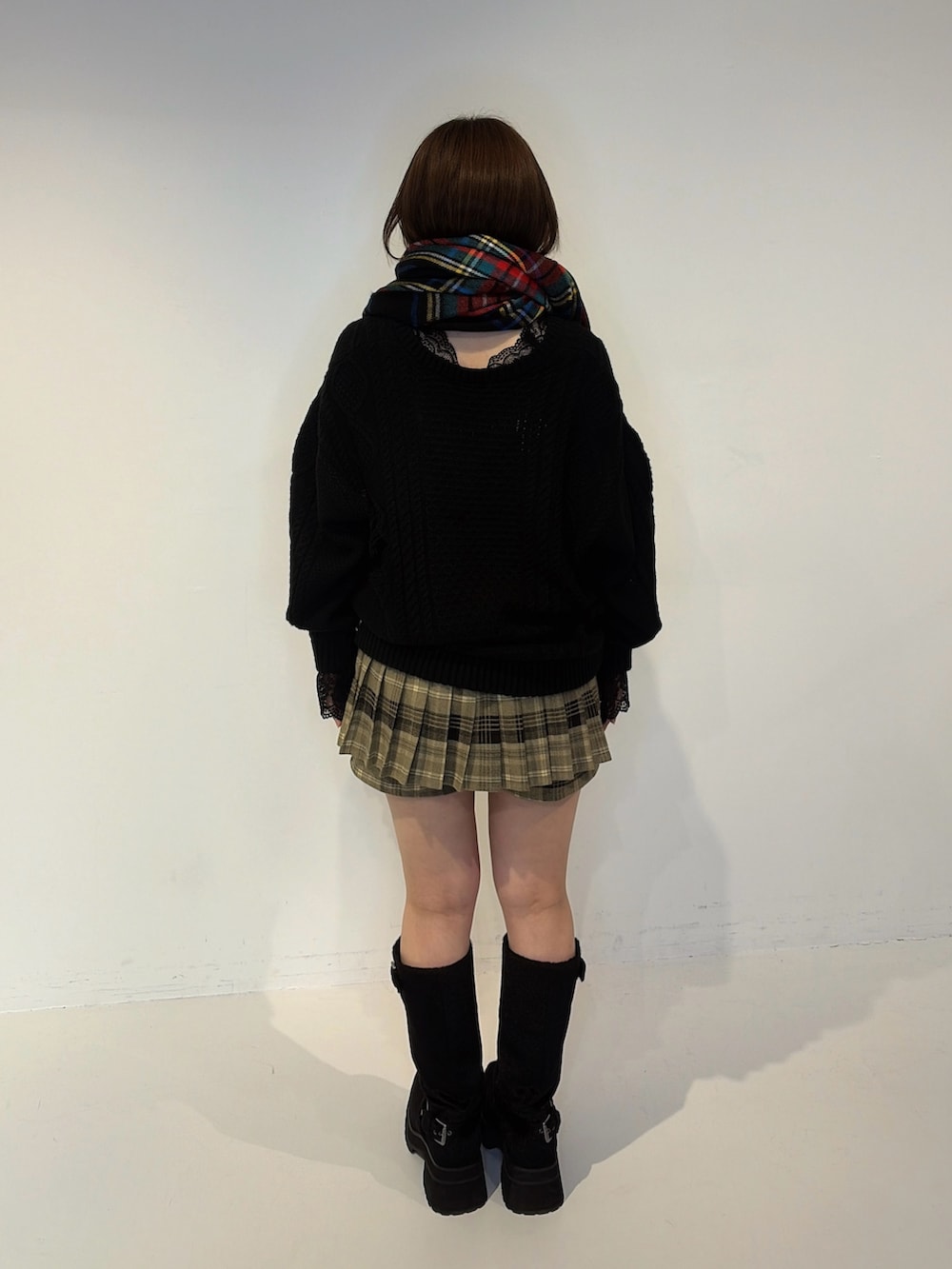 ブラック系のニット/セーター、ブラウン系のその他パンツ、ブラック系のブーツを着用したレディースの秋コーディネートの3枚目の写真
