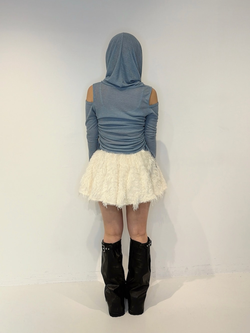 ブルー系のTシャツ/カットソー、ホワイト系のスカート、ブラック系のブーツを着用したレディースの秋コーディネートの4枚目の写真